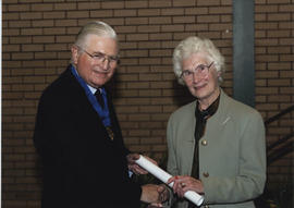 Photograph of Margaret Spouse receiving a scroll from Lord Mansfield at the AGM, 2004