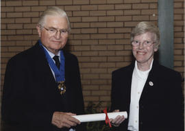 Photograph of Christine Traynor rreceiving a scroll from Lord Mansfield at the AGM, 2004