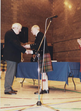 Photograph of John Drewry recieving a scroll from Bill Clement