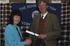 Photograph of Johan Maclean receiving a scroll from the Hon. Peregrine of Moncrieffe