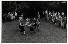 Photograph of a group of dancers dancing a circle