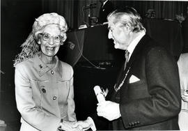 Photograph of Margaret Parker receiving a scroll from Lord Mansfield at the AGM, 1988